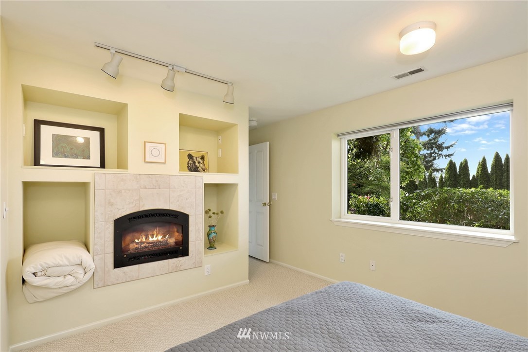 632 Fieldston Road Bellingham, WA 98225 - Photo 29 of 40 a living room with a fireplace and a floor to ceiling window