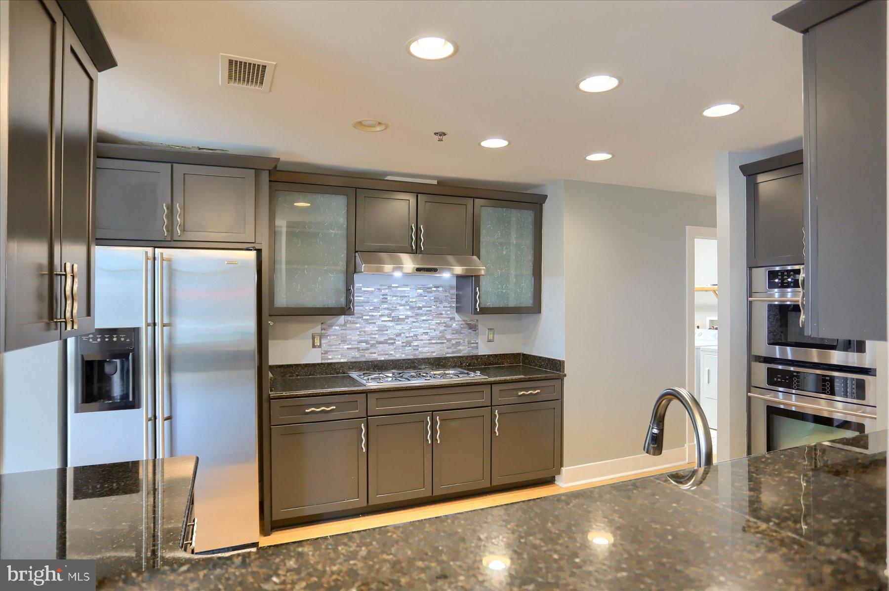 1400 Lancaster Street, Unit 802 Baltimore, MD 21231 - Photo 12 of 34 a kitchen with stainless steel appliances granite countertop a refrigerator and a sink