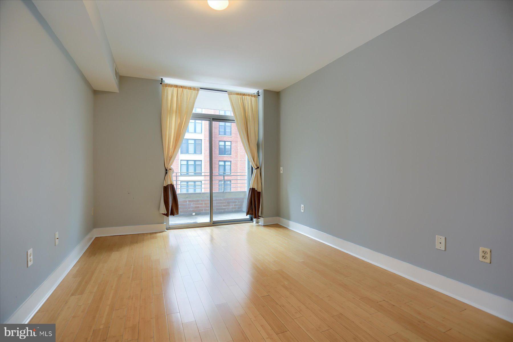 1400 Lancaster Street, Unit 802 Baltimore, MD 21231 - Photo 23 of 34 an empty room with wooden floor and windows