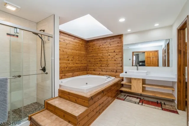 a bathroom with a tub a sink and a shower