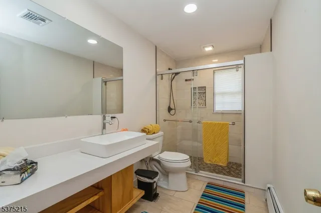 a bathroom with a sink toilet a mirror and shower