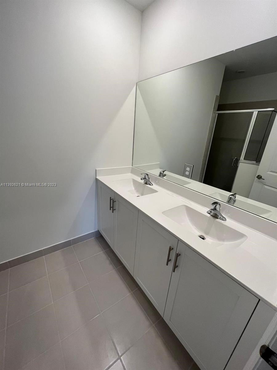 Miami-Dade County Homestead, FL 33032 - Photo 25 of 41 a bathroom with a double vanity sink and a mirror