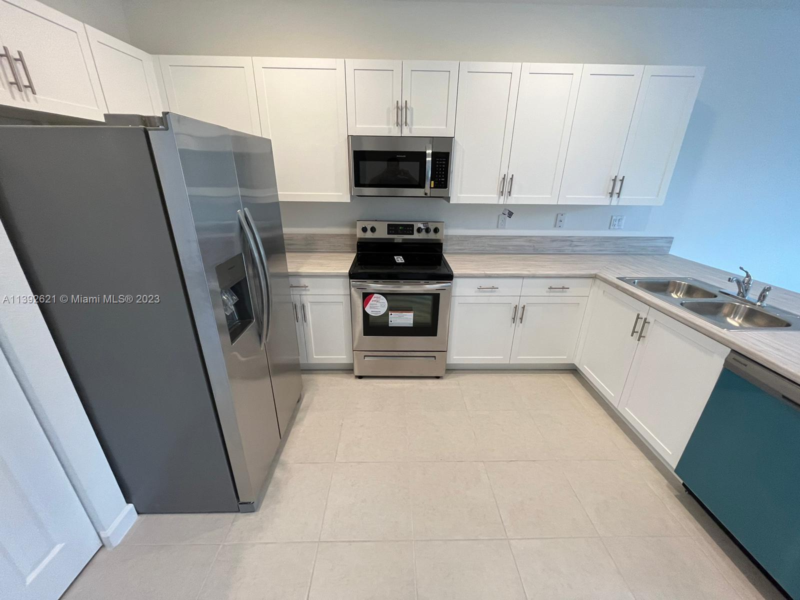 Miami-Dade County Homestead, FL 33032 - Photo 8 of 41 a kitchen with a refrigerator and a stove