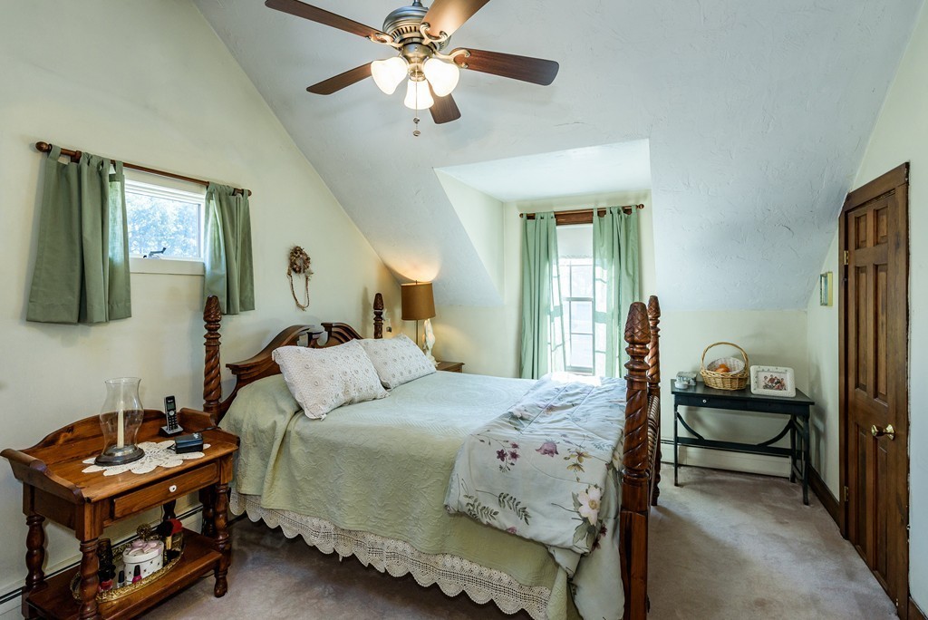 63 Johnson Street Boston, MA 02132 - Photo 7 of 13 a bedroom with a bed and a chandelier