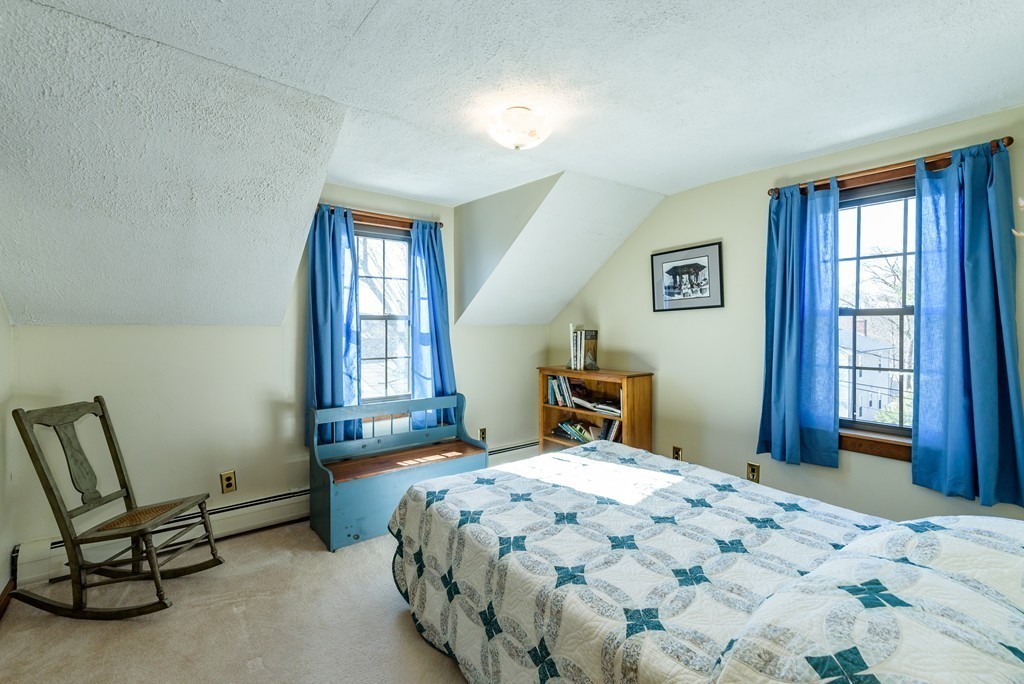 63 Johnson Street Boston, MA 02132 - Photo 8 of 13 a bedroom with a bed a table and chair