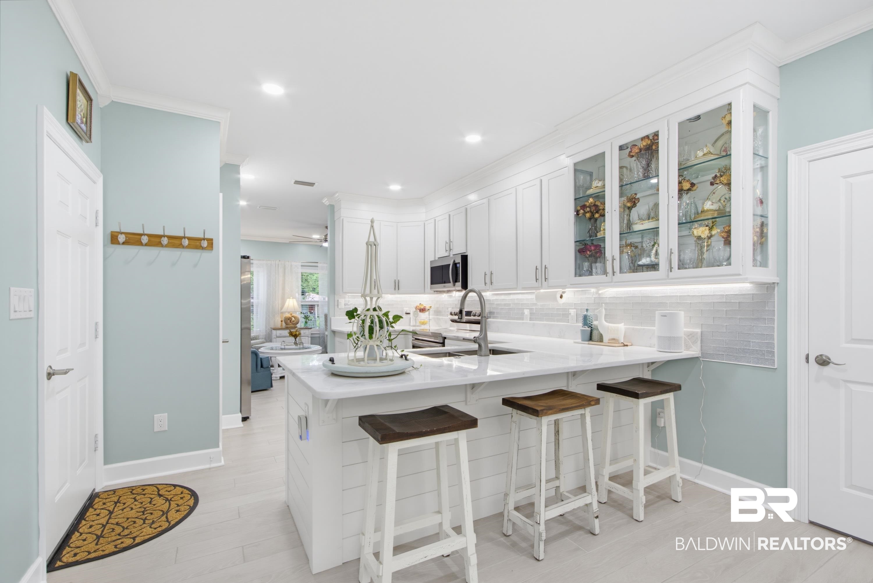 7472 Coopers Landing Road Foley, AL 36535 - Photo 10 of 40 Bright kitchen featuring white shaker cabinetry, an island with seating, a subway tile backsplash, and stainless steel appliances