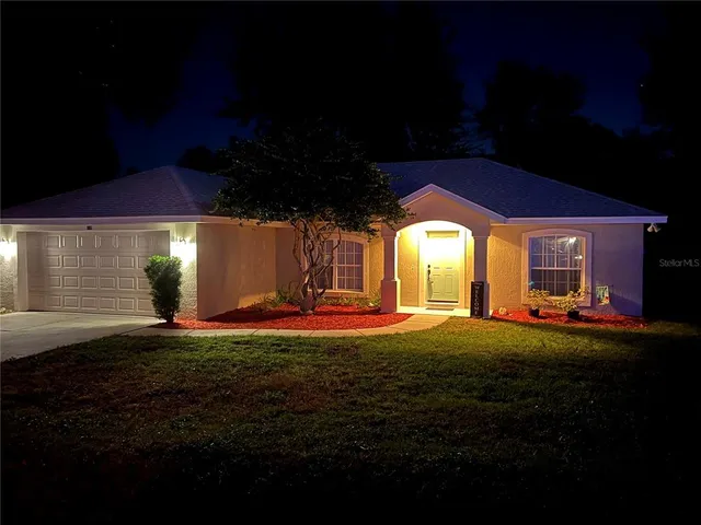 a view of a house with backyard and sitting area