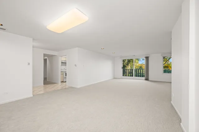 an empty room with windows and mirror