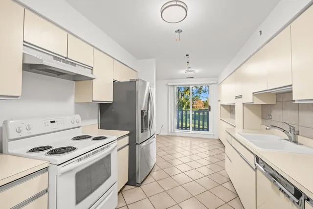 a kitchen with granite countertop white cabinets and white appliances