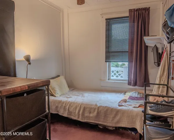 a bedroom with a bed next to a window