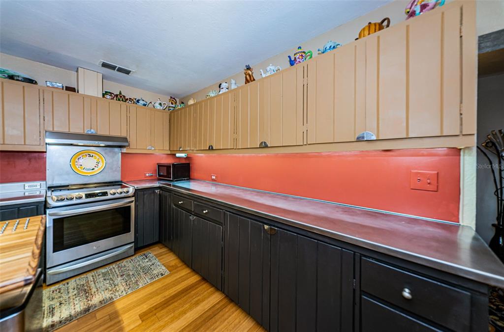 330 North Spring Boulevard Tarpon Springs, FL 34689 - Photo 12 of 34 a kitchen with stainless steel appliances a stove a microwave and cabinets