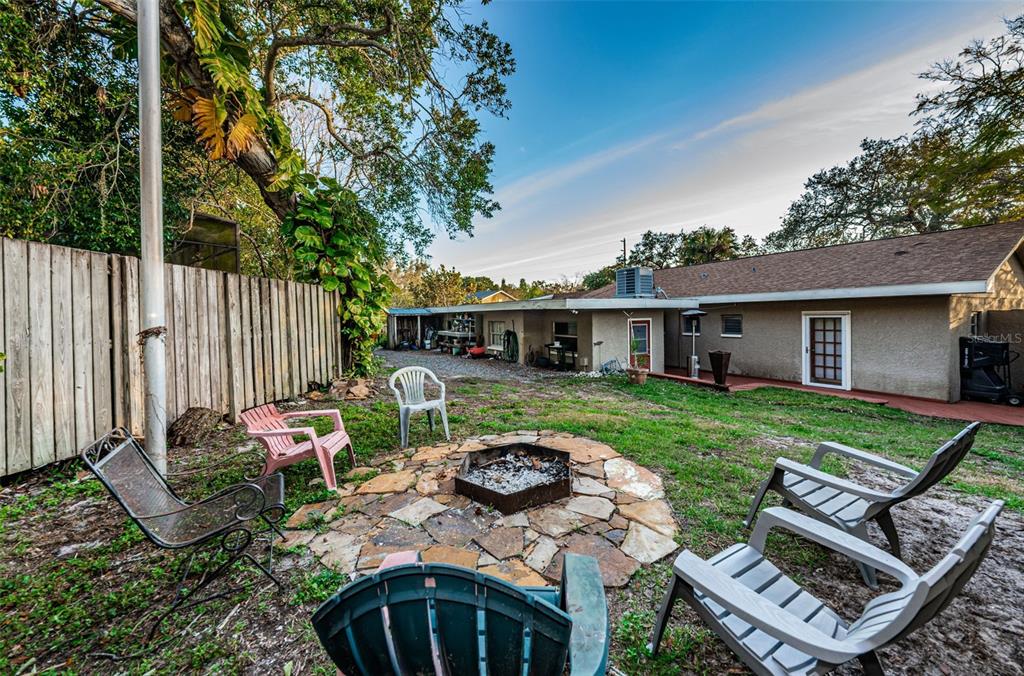 330 North Spring Boulevard Tarpon Springs, FL 34689 - Photo 31 of 34 a view of a backyard with table and chairs potted plants and a large tree