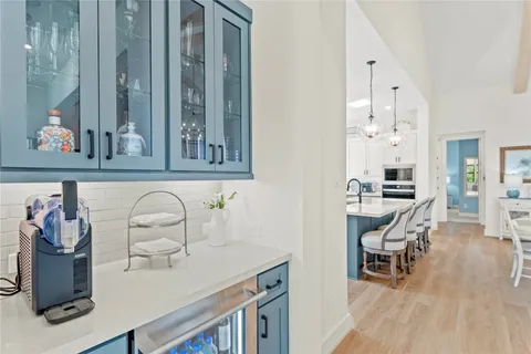 a dining room with wooden floor a chandelier a wooden table and chairs