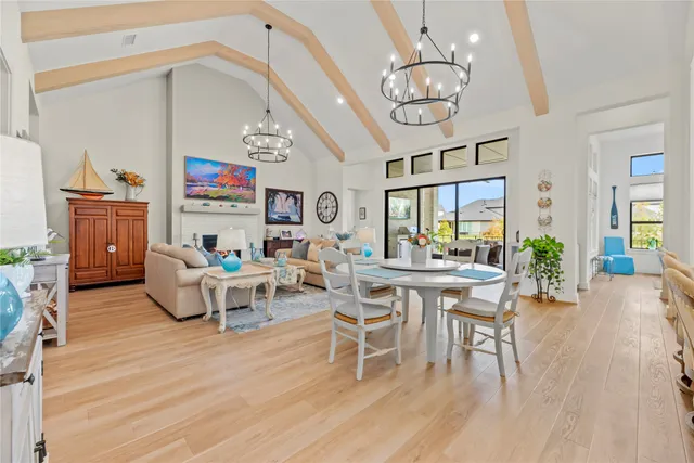 a work room with furniture a large window and a chandelier