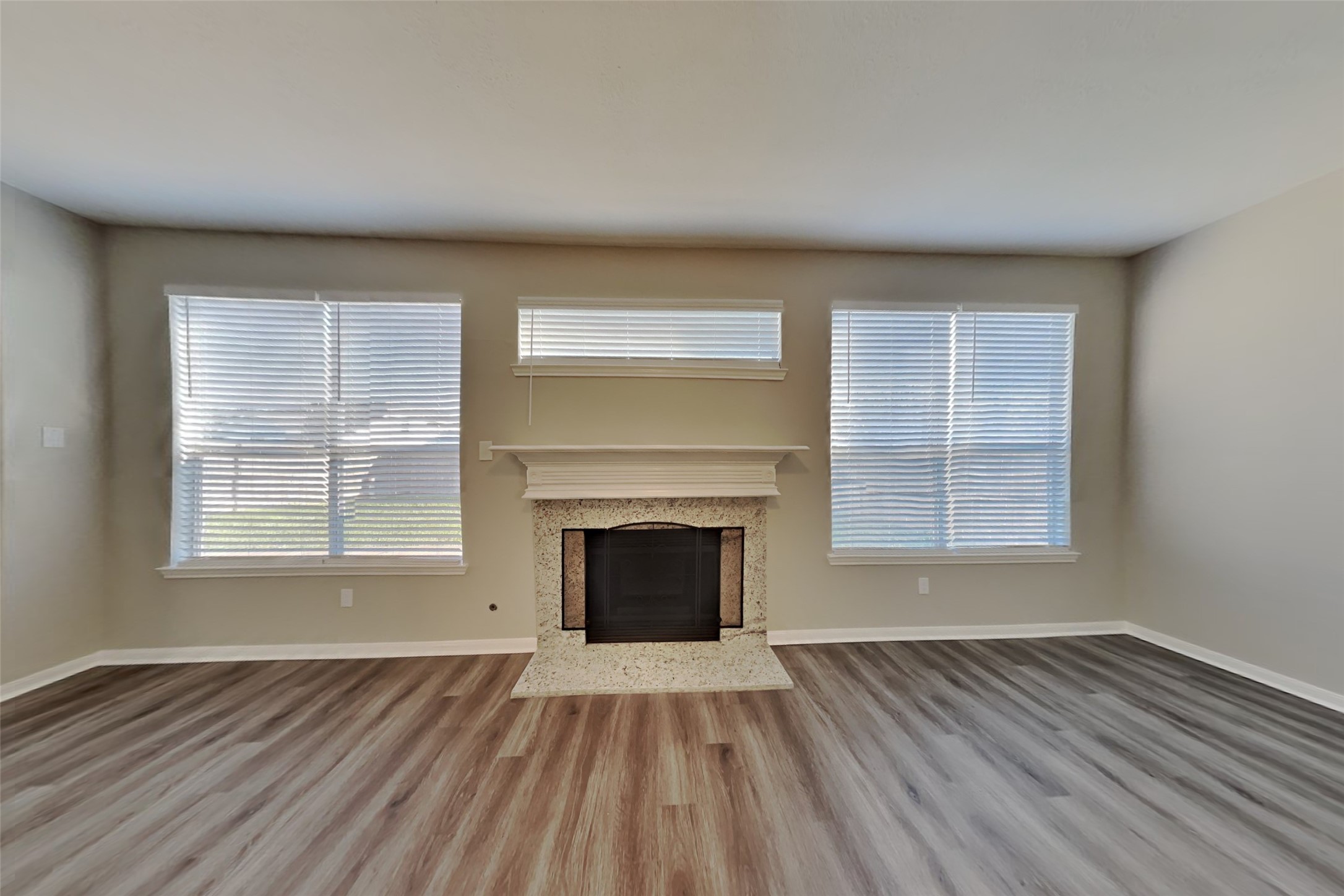21122 Covington Bridge Lane Spring, TX 77388 - Photo 5 of 26 an empty room with wooden floor fireplace and windows