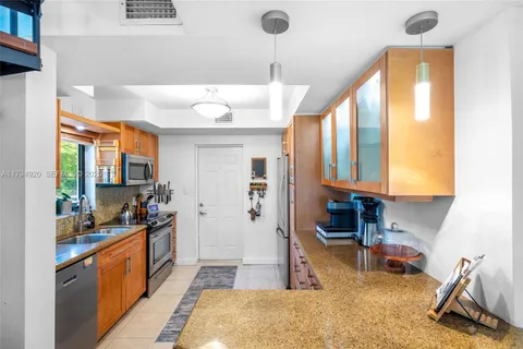 a kitchen with stainless steel appliances granite countertop a sink a stove and a refrigerator