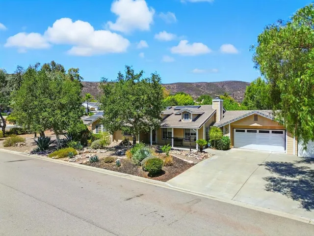 a front view of a house with a yard and street