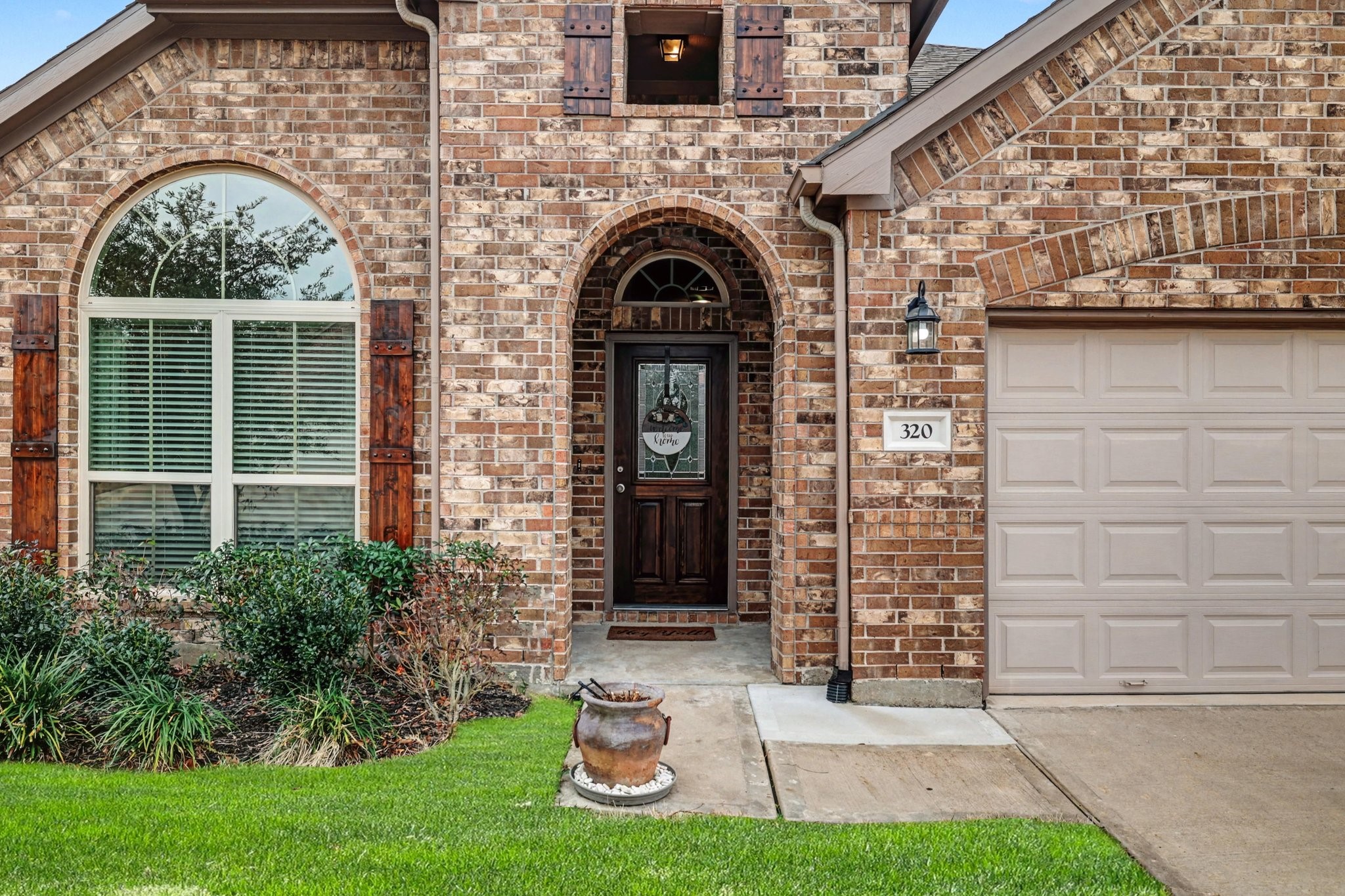 320 Red Maple Lane Conroe, TX 77304 - Photo 3 of 24 Arched entry and window featuring a solid wood door, decorative glass, and custom shutters.