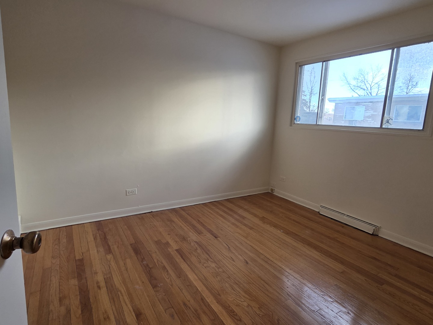 8649 Niles Center Road, Unit B Skokie, IL 60077 - Photo 11 of 22 an empty room with wooden floor and windows