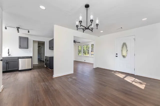 a view of a kitchen with a sink a refrigerator and wooden floor