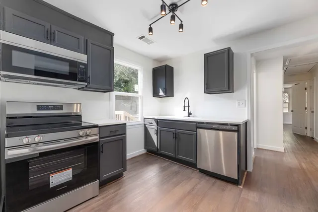 a kitchen with stainless steel appliances kitchen island granite countertop a stove and a microwave