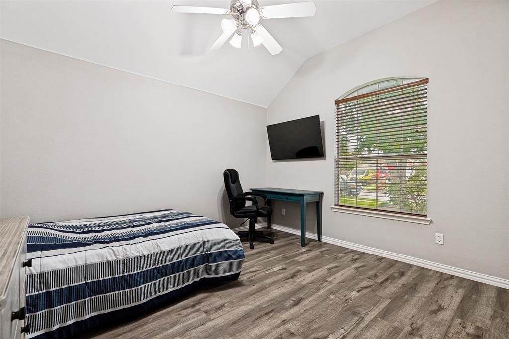 4305 Ridgewood Road Melissa, TX 75454 - Photo 16 of 26 Vaulted ceiling bedroom with wood-finish flooring, an arched window, and a ceiling fan with light fixture