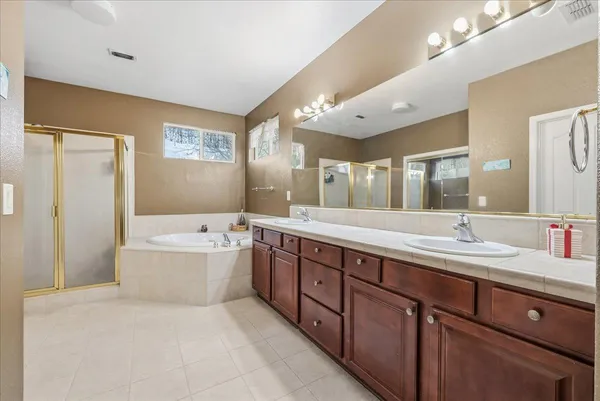 a spacious bathroom with a large tub shower and sink