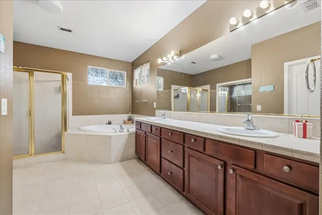 a spacious bathroom with a large tub shower and sink