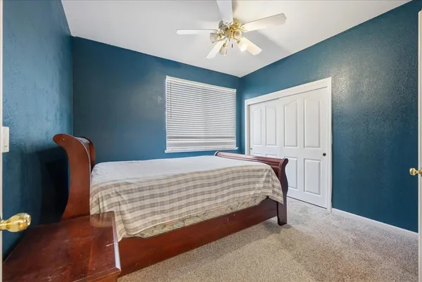 a bed sitting in a spacious bedroom next to a window