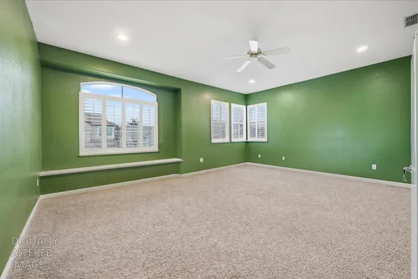 a view of an empty room with a window and a ceiling fan