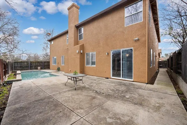 a view of a house with backyard and a tree