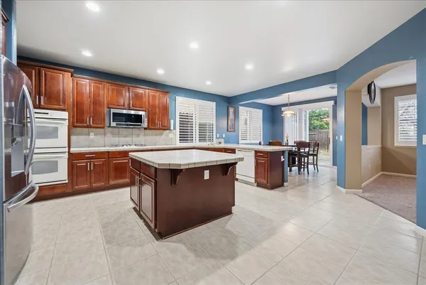 a kitchen with kitchen island a sink counter top space appliances and a window