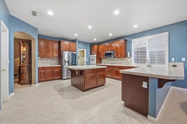 a kitchen with stainless steel appliances granite countertop wooden cabinets a sink and a large window