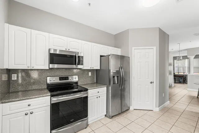 a kitchen with stainless steel appliances granite countertop a stove a sink and a microwave