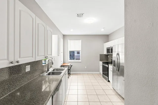 a kitchen with stainless steel appliances granite countertop a refrigerator and a stove top oven
