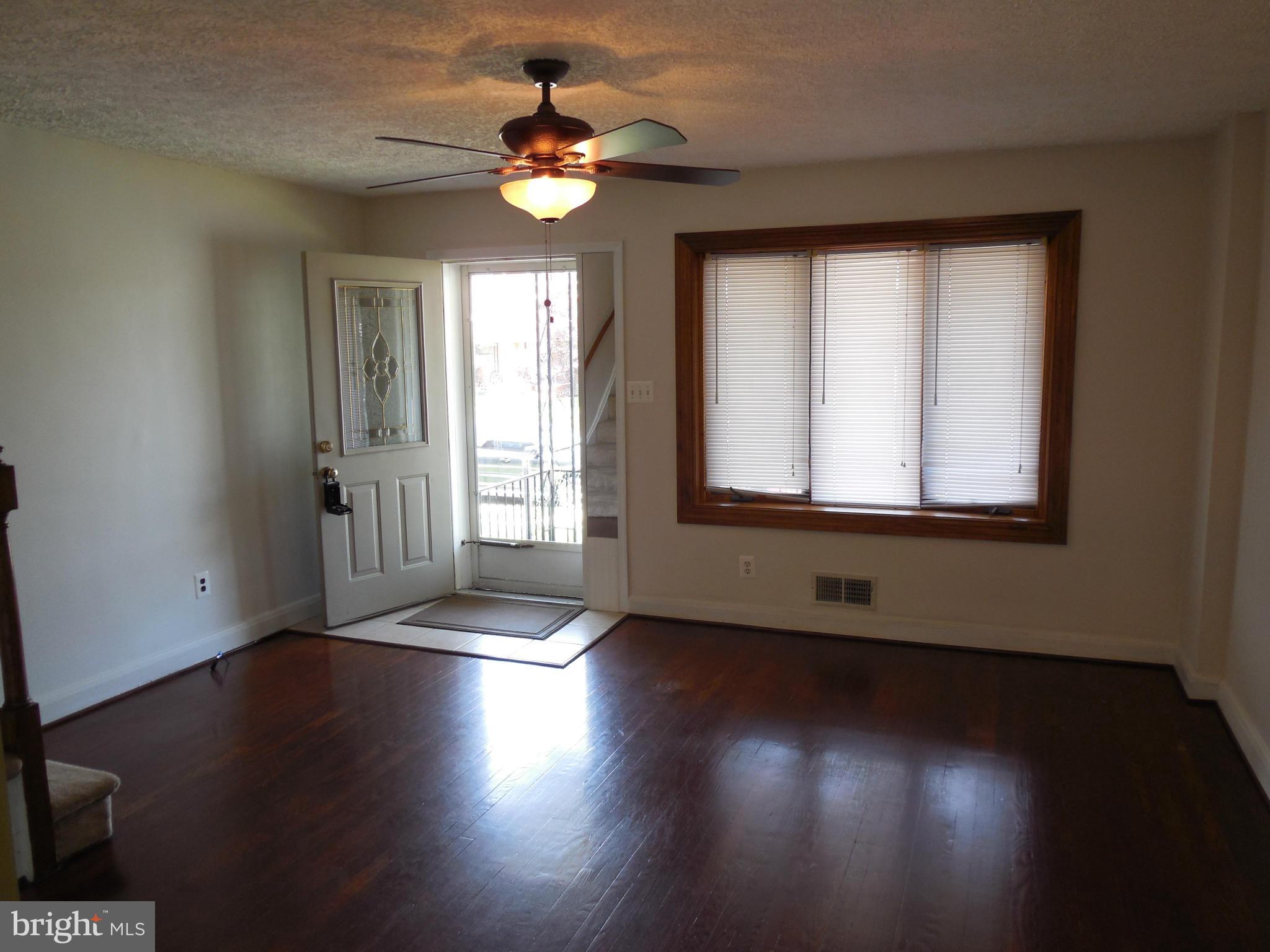 446 Grovethorn Road Baltimore, MD 21220 - Photo 2 of 25 a view of an empty room with wooden floor and a window