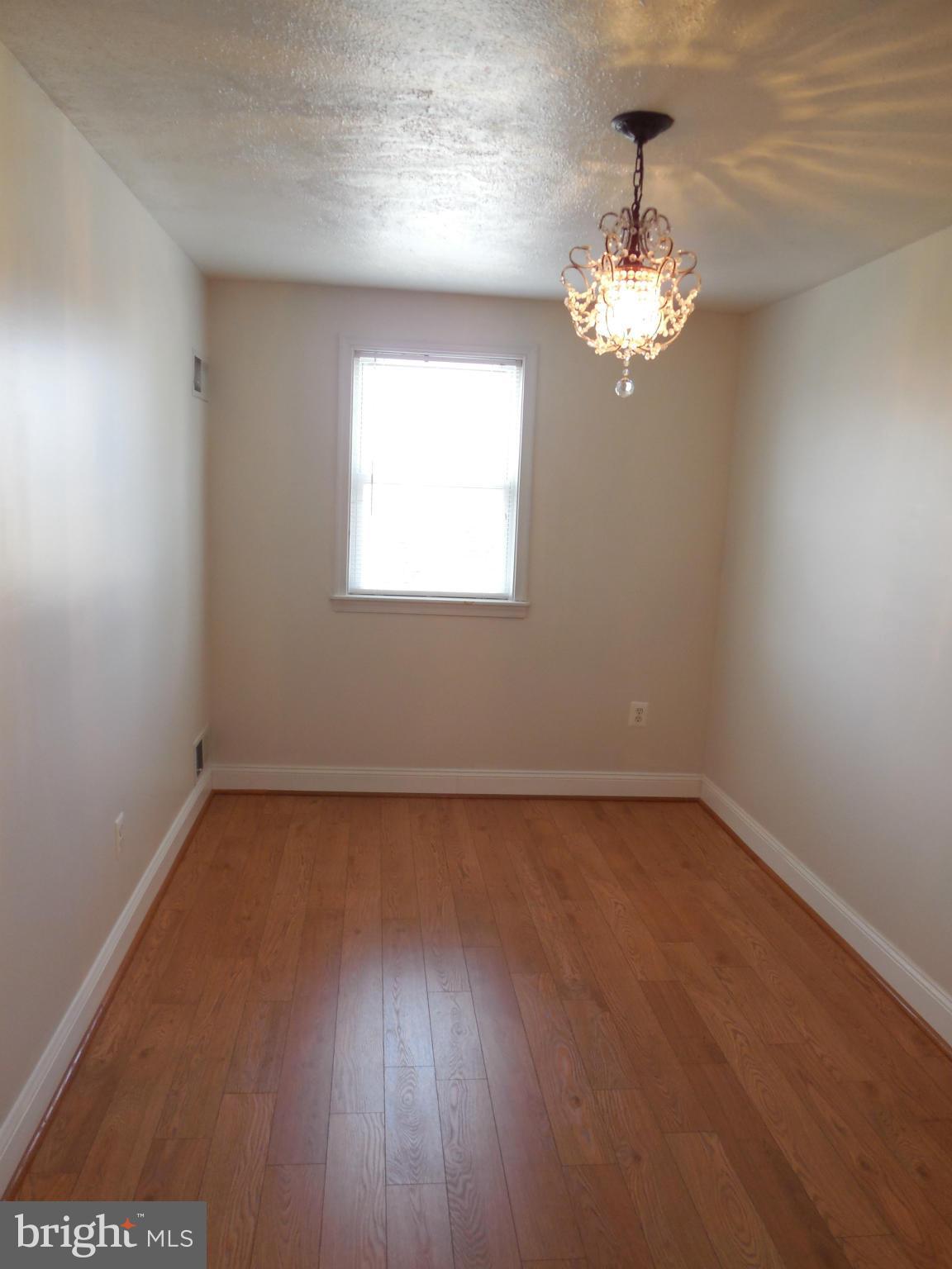 446 Grovethorn Road Baltimore, MD 21220 - Photo 12 of 25 a view of a room with wooden floor and chandelier