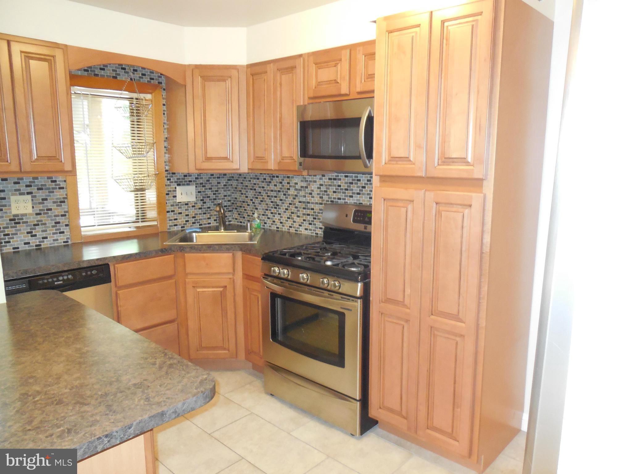 446 Grovethorn Road Baltimore, MD 21220 - Photo 7 of 25 a kitchen with stainless steel appliances granite countertop a stove a sink and a microwave