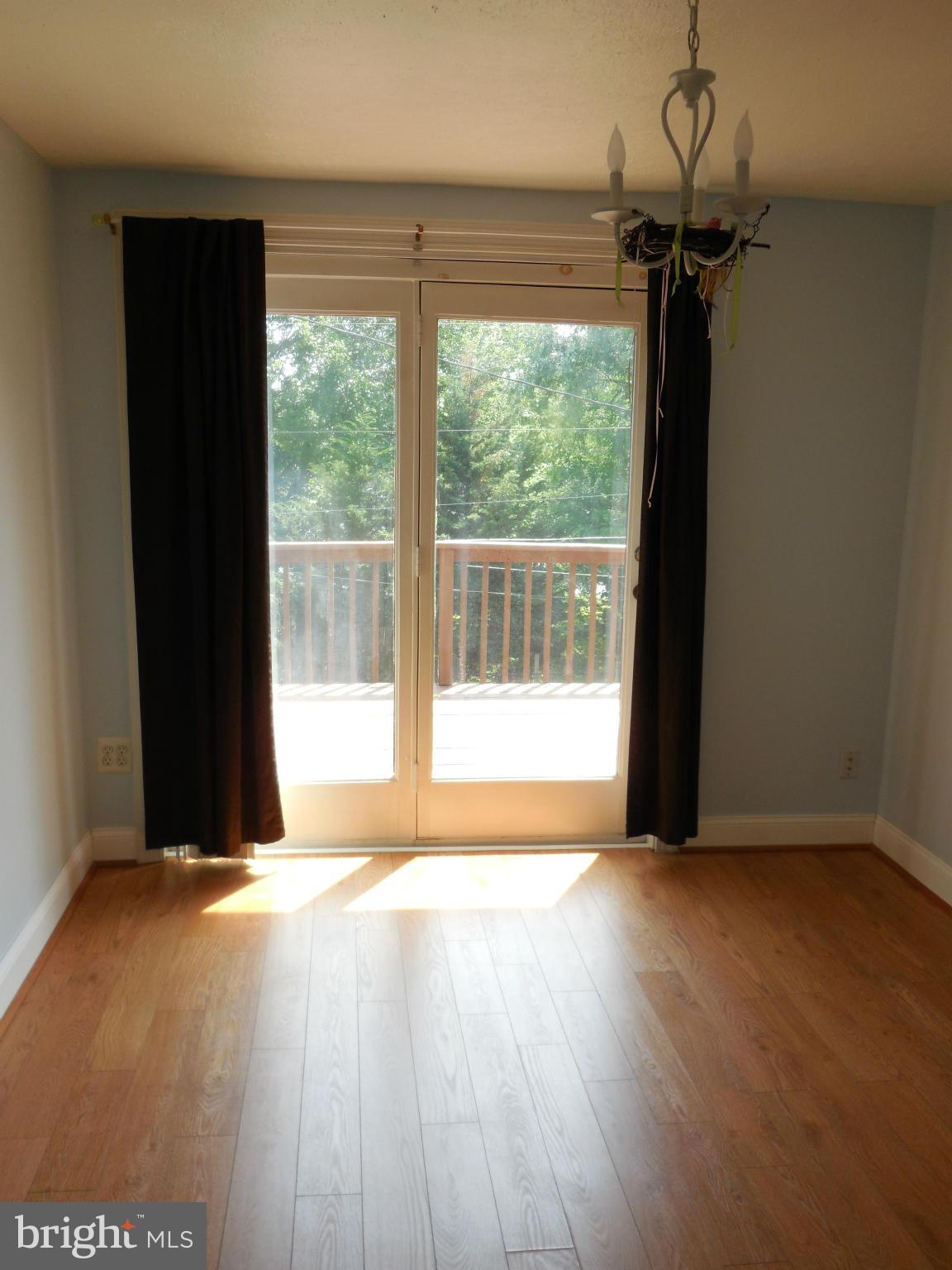 446 Grovethorn Road Baltimore, MD 21220 - Photo 10 of 25 a view of an empty room with a window and wooden floor
