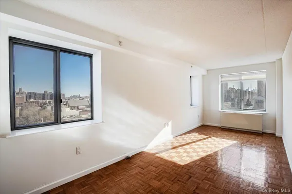 a view of an empty room with window and closet area