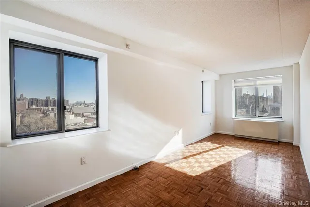 a view of an empty room with window and closet area