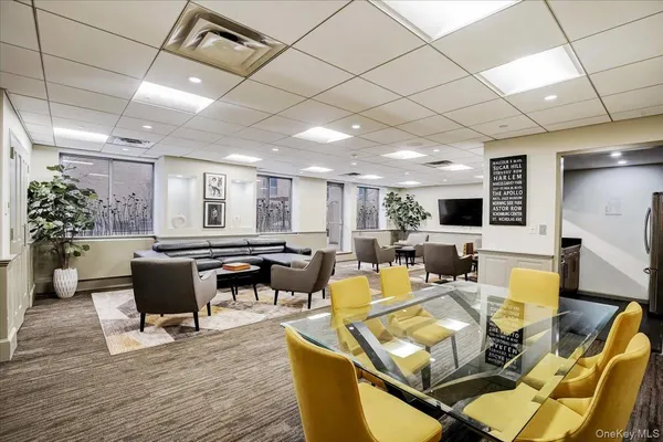 a living room with furniture kitchen view and a wooden floor