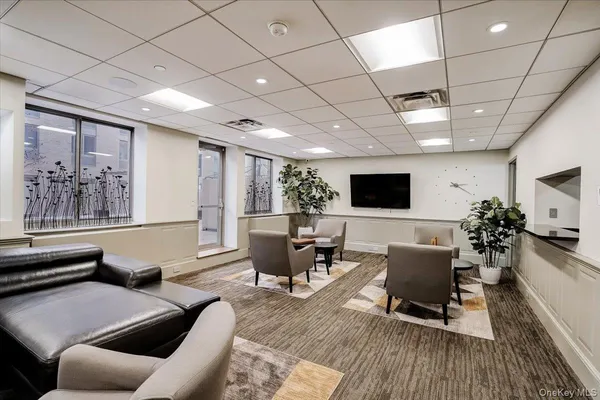 a living room with furniture a flat screen tv and a large window