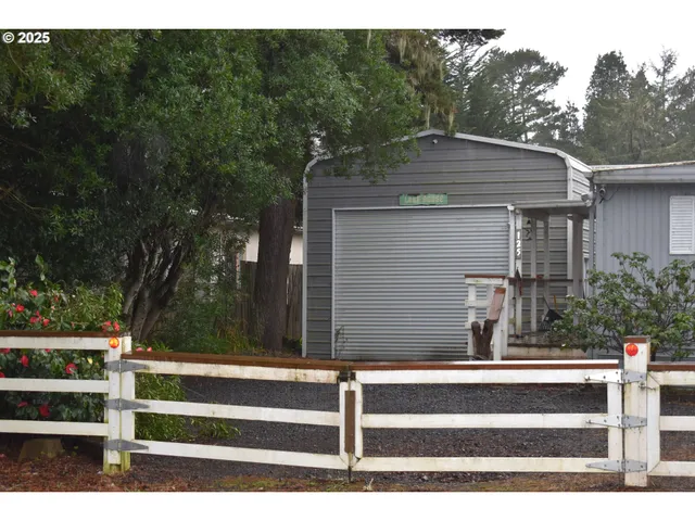 a view of backyard with wooden fence and large trees