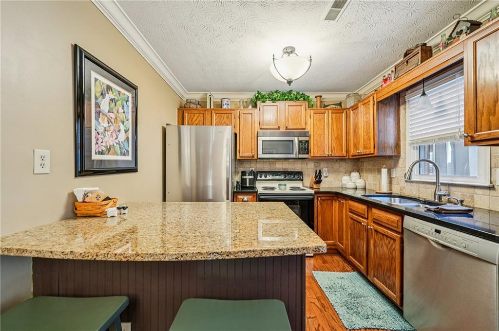 4166 Oakwood Way Duluth, GA 30096 - Photo 6 of 28 a kitchen with granite countertop stainless steel appliances a sink a counter space and a window