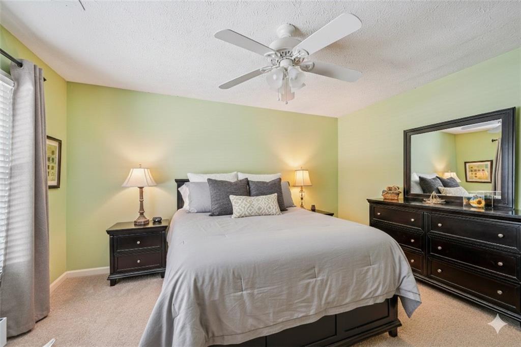 4166 Oakwood Way Duluth, GA 30096 - Photo 10 of 28 a bedroom with a bed and a dresser in it
