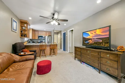 a living room with furniture kitchen view and a chandelier