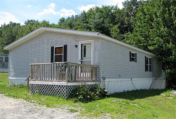 154 Great Road, Unit 4 Shirley, MA 01464 - Photo 15 of 16 a view of a house with a small yard and wooden fence