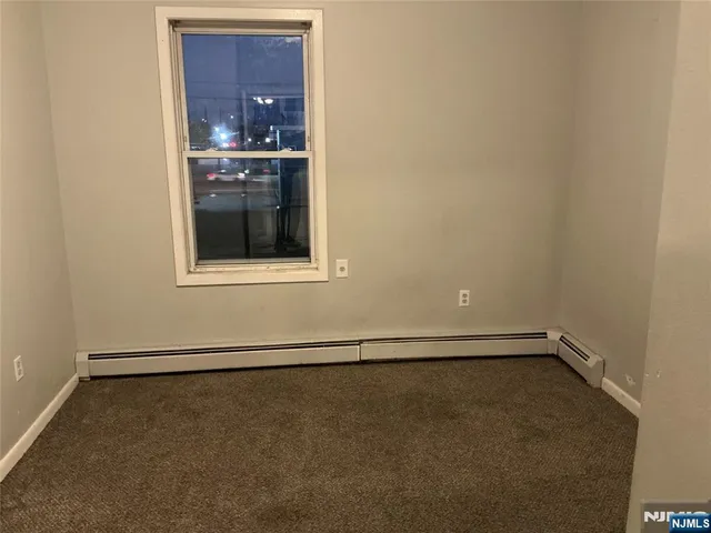 a view of an empty room with a kitchen