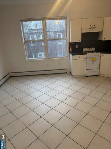 a living room with a wooden floor and a cabinet